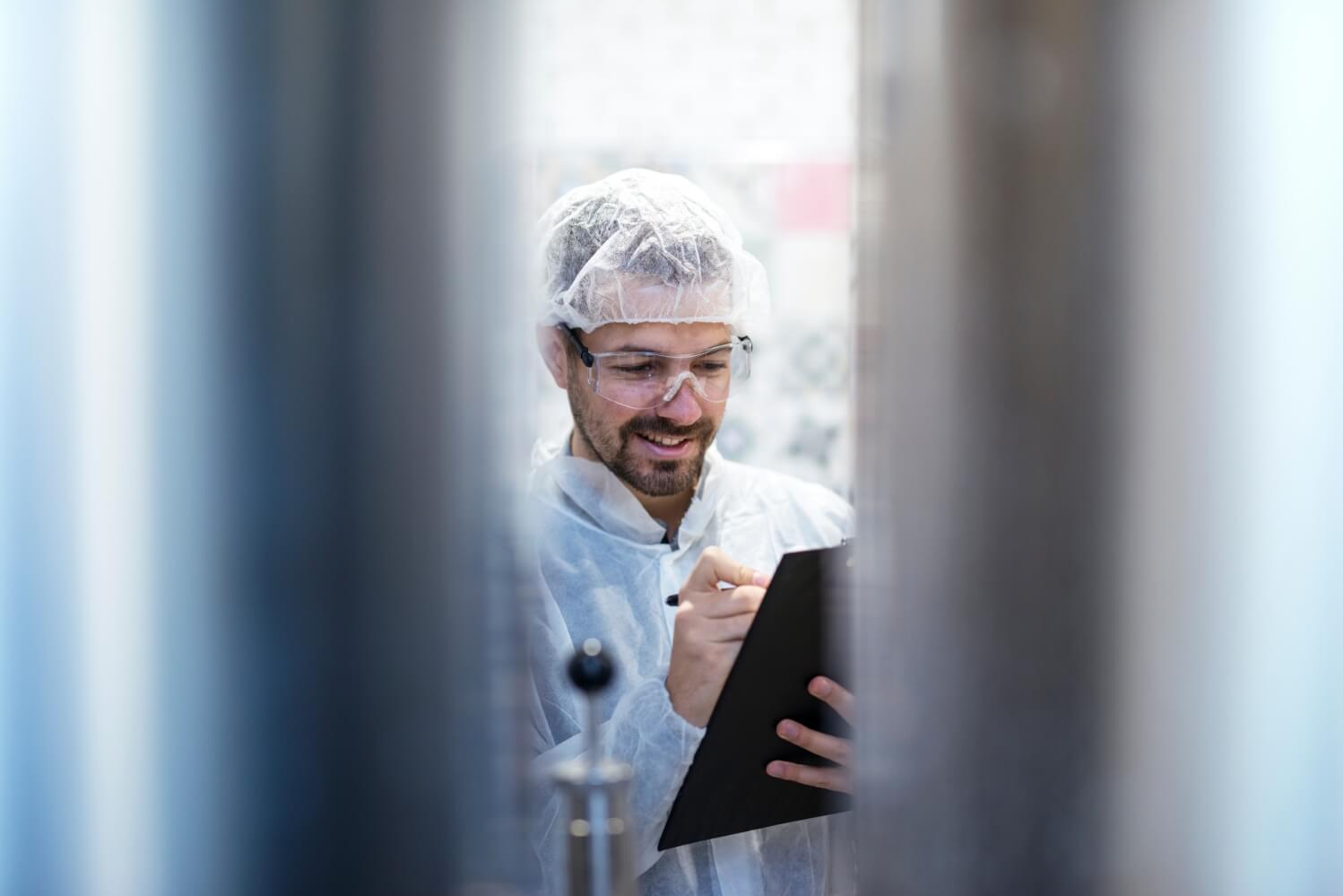 man carrying clipboard in sanitary warehouse